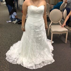 Never worn wedding dress. Bought from David’s bridal Size 16. It was hemmed.